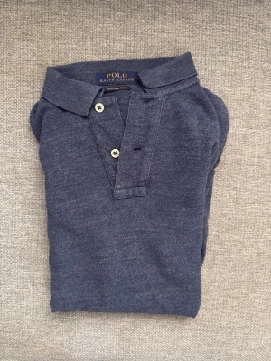 Blå pikétröja från Polo Ralph Lauren - Mörkblå pikétröja från Polo Ralph Lauren. Storlek S. (182 70KG)