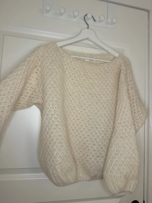 Stickad vit/krämbeige tröja  - Supermysig krämvit stickad tröja med fluffig mysigt mönster. Skit snygg på och den är hålstickad, på bilden har jag en t shirt under, denna är perfekt inför hösten.💕Kan alltid skicka mått privat!