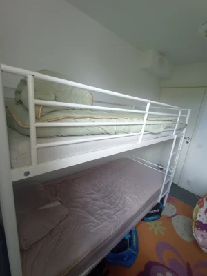 Vit våningssäng i metall - Säljer en stilren vit våningssäng i metall med två plan. Sängen har skyddsräcken på övre delen och en stege på sidan. Perfekt för barnrummet eller tonårsrummet. Madrasser och täcken ingår inte. Den är 90x200. Endast upphämtning i Göteborg 