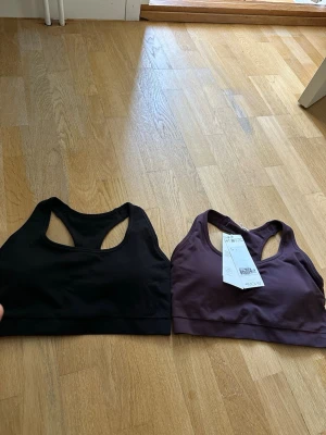2-pack sport bhar från H&M Move - Säljer ett 2-pack sport bhar från H&M Move i storlek L. Ena är svart och den andra är mörklila. Båda har brottarrygg och är tillverkade i ett stretchigt, mjukt material som andas. Perfekta för träning eller chill dagar.