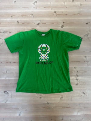 Grön Baby Milo t-shirt från BAPE - Säljer en grön t-shirt från A Bathing Ape med Baby Milo-tryck.