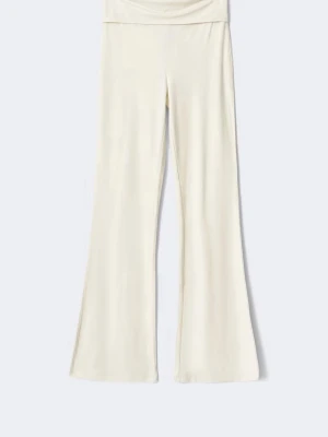 Vita yoga pants - Snygga vita yoga pants med utsvängda ben. Byxorna har en bred midjeresår och sitter bekvämt på kroppen. Perfekta för en avslappnad stil hemma eller när du vill chilla. Materialet ser ut att vara mjukt och stretchigt.