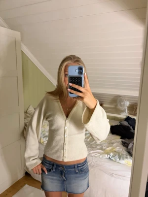 Vit kofta - Söt vit kofta med v-ringning och pärlknappar framtill. Modellen har långa, lite vidare ärmar och ribbad midja som ger en snygg siluett. Perfekt att styla med jeans eller kjol för en trendig look. Har tagit bort knapparna som satt upp mot halsen för tyckte dom såg konstiga ut💕💕