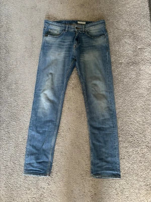 Ljusblå slim fit jeans - Säljer ett par ljusblå slim fit jeans med klassisk design, de är raka ben. Skick 8,5/10 ny pris: 1399 storlek 31/32