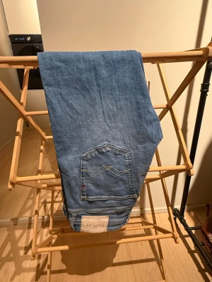 Ljusblå raka jeans från Replay - Säljer ett par ljusblå jeans från Replay med klassisk femficksmodell och raka ben. Jeansen har en snygg tvätt och detaljerad bakficka med broderi. Perfekta för en avslappnad och trendig look. Nypris 1850kr