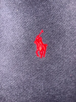 Mörkblå skjorta från Polo Ralph Lauren - Klassisk mörkblå skjorta från Polo Ralph Lauren med den ikoniska röda polospelaren broderad på bröstet. Skjortan är tillverkad i mjuk bomull och har en tidlös design som passar till många olika stilar.