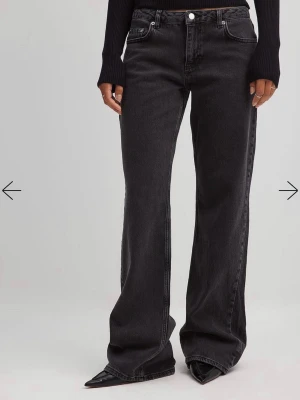 Vida svarta jeans med låg midja - Är 178cm lång! Säljs då de är för stora! Säljer ett par svarta jeans med låg midja och raka, vida ben. Jeansen har klassisk femficksmodell och silverfärgade knappar. Perfekta för en avslappnad och trendig look. Materialet är denim i bomull.