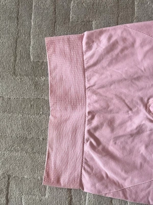 Rosa seamless leggings från Lager 157 - Säljer ett par ljusrosa seamless leggings från lager 157 med hög midja och ribbad struktur. Perfekta för träning eller chill, med stretchigt material som sitter skönt och formar sig efter kroppen. Diskret logga framtill i vitt.