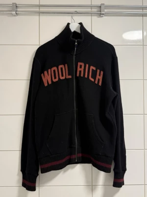 Woolrich zip- cardigan strorlek -L - Woolrich ulltröja / zip cardigan – Storlek L   Storlek: L Material: Ull Färg: Svart / vinröd Skick: Begagnat, fint skick Nypris: Woolrich ulltröjor ligger vanligtvis omkring 2 000–3 000 kr beroende på modell.   Skickar samma dag ! 
