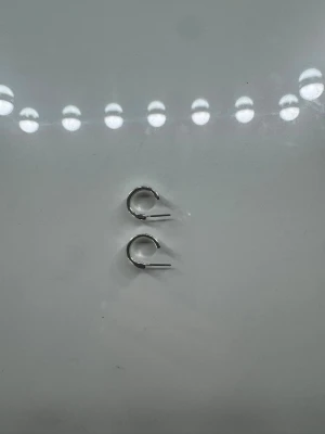 Små silvriga hoops örhängen - Säljer ett par små, klassiska hoops i silverfärgad metall. De har en enkel och stilren design som passar till allt. Perfekta för dig som gillar minimalistiska smycken och vill ha något diskret men snyggt i öronen.