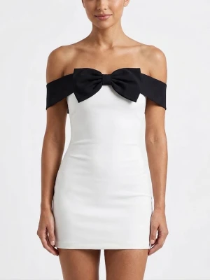 Vit offshoulder klänning med rosett - Supersnygg vit kortklänning med offshoulder-design och en stor svart rosett över bysten. Klänningen har en figurnära passform och är perfekt för dig som vill sticka ut. Materialet ser ut att vara polyester eller liknande för en slät finish.