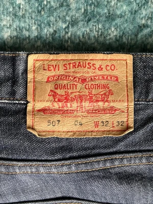 Levi's 507 raka blå jeans - Säljer ett par blå Levi's 507 jeans med rak passform och är mid-waist. Tidlösa, snygga jeans! Lite slitna i botten. Storlek: W32, L32