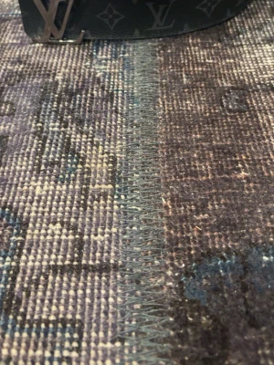 Svart Louis Vuitton bälte i skinn - Snyggt svart bälte från Louis Vuitton med klassiskt monogrammönster och LV-spänne i metall. Bältet är gjort i skinn och har en stilren design som passar till många olika outfits. Bältet är 80cm långt.