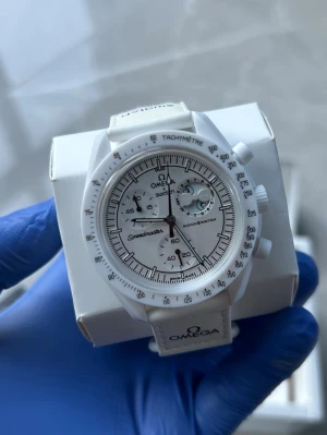 Omega x Swatch Speedmaster  - Snygg Omega x Swatch Speedmaster MoonSwatch i helvitt med tydliga svarta detaljer. Klockan har tachymeter, flera urtavlor och vit textilrem med Omega-logga. Perfekt för dig som gillar stilrena accessoarer med ikonisk design.