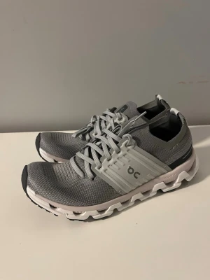 Gråa On Cloud sneakers - Snygga gråa On Cloud sneakers med vit och svart sula i storlek 43 och är helt oanvända. Genuint de skönaste sommar och tränings skorna