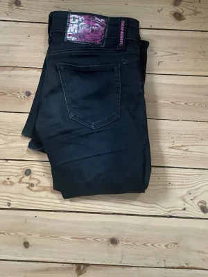 Svarta bootcut jeans - Snygga svarta jeans med bootcut passform och klassisk femficksdesign. Jeansen har dragkedjegylf och bälteshällor, perfekta till en avslappnad stil. Materialet är stretchigt för extra komfort. Dom har en repa i märket på baksidan se på bild 3 men det syns inte så mycket💕