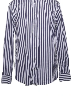 Suitsupply randig skjorta i blått och vitt (44)  - Snygg randig skjorta ifrån Suitsupply med vertikala blå och vita ränder. Klassisk krage, knäppning framtill och långa ärmar med manschetter. Perfekt för en stilren och trendig look. Tillverkad i ett lätt och bekvämt tyg.