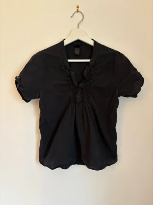 Svart kortärmad blus 💗 - En svart, kortärmad blus från H&M, köpt second hand. Storlek 38/M, använt skick 💗
