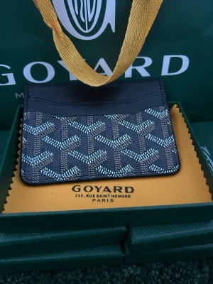 Svart plånbok - Snyggt svart kortfodral med det klassiska mönstret i vitt och grått. Tillverkat i läder med flera kortfack och stilren design. Perfekt för dig som vill ha en exklusiv och smidig plånbok i fickformat.