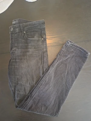Svarta jeans från Jack & Jones 30/32 - Snygga svarta jeans från Jack & Jones med klassisk femficksmodell och smal passform. Jeansen har en lätt tvättad look och är tillverkade i stretchigt denimtyg för extra komfort.