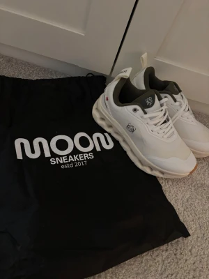 Skor från oncloud collab med LOEWE - Säljer ett par helt nya aldrig andvända  vita  sneakers från oncloud  med gröna detaljer. Skorna har cool logga på sidan. Sulan är vit med beige/gummifärgad tå. Perfekta för dig som gillar att gå eller springa