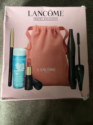 Lancôme Travel Exclusive sminkset - Snyggt sminkset från Lancôme Travel Exclusive med mascara, läppstift i nude, ögonpenna, makeup-remover och en rosa tygpåse. Perfekt för dig som vill ha allt i ett kit. Allt kommer i en fin rosa förpackning.