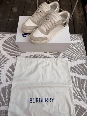 Burberry vita sneakers med rutigt mönster - Storlek EU 42, garanterat äkta. Köpta på Miinto. Nypris ligger på 6900sek