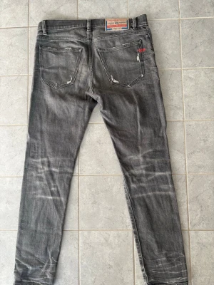 Gråa Diesel jeans med slitningar - Säljer ett par gråa jeans från Diesel med snygga slitningar på bakfickorna och Jeansen har raka ben och har inte använts ofta alls. L30 W30