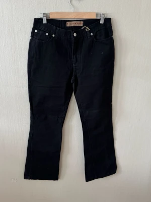 Svarta bootcut jeans från Richmond  - Säljer ett par svarta bootcut jeans från Richmond. Jeansen har klassisk femficksdesign, raka ben med lätt utsvängning och silverfärgade nitar. Materialet ser ut att vara denim med en mjuk finish. Perfekta för en cool och avslappnad stil.0084