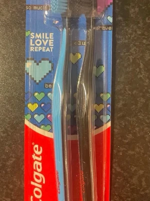 Colgate tandborstar 2-pack - Två tandborstar från Colgate i förpackning, en blå och en svart. Ergonomiskt formade handtag och mjuka borst. Perfekt för daglig tandvård och enkel att ta med på resan.