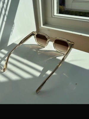 Beige solglasögon från CHIMI - Snygga solglasögon från CHIMI i färgen Ecru med fyrkantig form och bruna tonade glas. Alla tillbehör ingår. De har en pytteliten skråma på ena linsen som knappt syns.