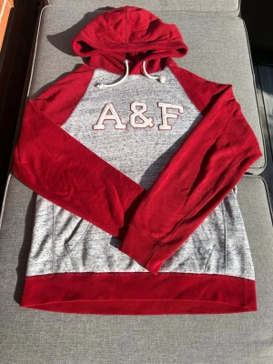 Abercrombie and fitch hoodie - Ruggigt fet hoodie från Abercrombie and fitch i röd och grå färg. Storlek M. Har inte så mycket mer att säga men kommer passa extremt bra nu till hösten och vintern. Hör gärna av er om ni undrar något!!!