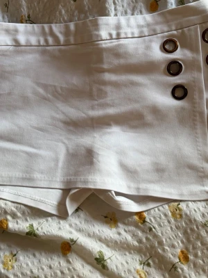 Vita shorts med ringdetaljer