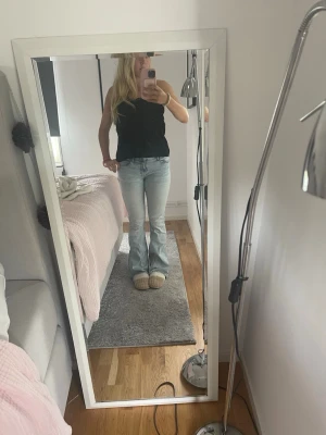 Ljusblå bootcut jeans - Säljer ett par ljusblå bootcut jeans med klassisk femficksmodell och normal midja. Jeansen har en avslappnad passform över låren och utsvängda ben. Perfekta för en trendig och avslappnad stil.