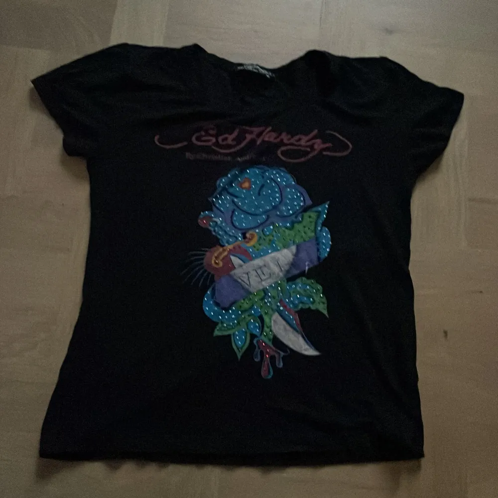 Jättecool baby tee från ed hardy. Bra skick, ingen rhinestone har ramlat av vad jag kan se. Skulle säga storlek xs men är väldigt stretchig så kan passa större också. Skriv om du har frågor, använd gärna köp nu🩷. T-shirts.