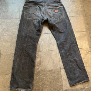 Svarta jeans med slitningar - Säljer ett par svarta carhartt jeans med coola slitningar på framsidan. De har en en bekväm passform, med snygg wash