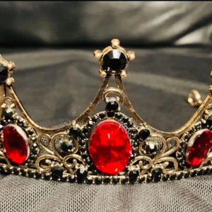 Krona Tiara Drottning Kung Gothprinsessa Metal Maskerad Burlesque Vampyr Häxdrottning Gala Retro - En krona / tiara värdig en vampyrdrottning, mörkeralv eller gothprinsessa.  Så vacker och välgjord med glittrande röda och svarta stenar mot mörkt guldfärgad ram. Bredd 15 cm, båglängd 29 cm, höjd längst fram 5 cm.   Gediget gjord, bekväm att bära. 