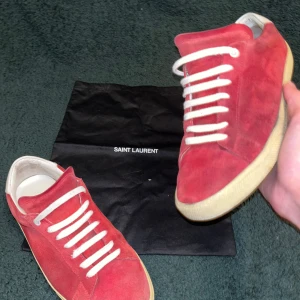 Saint Laurent SL/06 - Säljer de här feta Saint Laurent skor i Röd mocka. De är i ok skick(8). Storlek 40. Defekt: texten är borta på sulan(bild 4).
