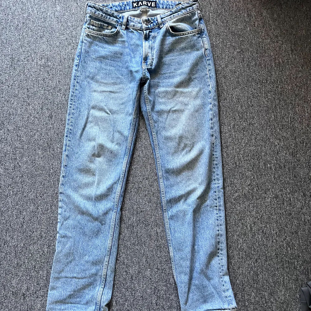 Säljer ett par snygga blå jeans från Karve. De har en klassisk design med fem fickor och knappgylf. Perfekta för vardagsbruk och kan enkelt matchas med olika outfits.. Jeans & Byxor.