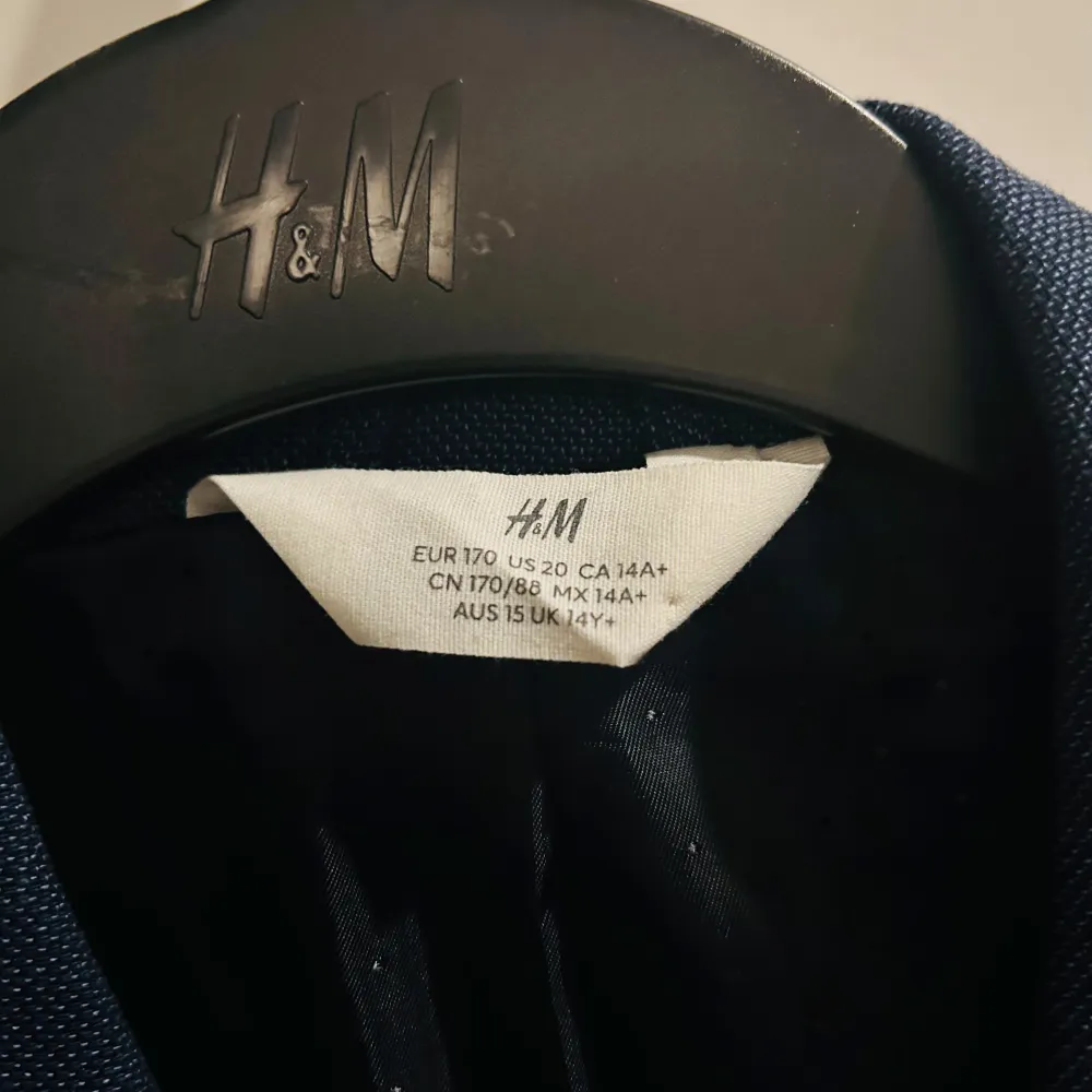 Säljer en stilren blå kavaj från H&M i storlek M. Perfekt för både formella och semi-formella tillfällen. Kavajen har en klassisk passform med två fickor framtill och en bröstficka. Materialet känns lätt och bekvämt, vilket gör den idealisk för vår och sommar.. Kostymer.