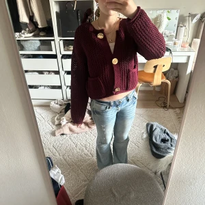 Vinröd stickad kofta från Zara - Säljer en vinröd stickad kofta från Zara med stora guldknappar och två fickor framtill. 