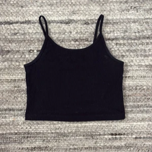 Svart ribbad linnetopp från FB Sister - Säljer en svart ribbad linnetopp från FB Sister i storlek XS. Toppen har smala axelband och en enkel design som passar perfekt till vardags eller som basplagg. Pris kan även diskuteras❤️