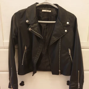 Svart skinnjacka från Ellos 🤩 - Snygg svart skinnjacka från Ellos med coola silvriga dragkedjedetaljer och knappar. Hör gärna av er vid frågor!🤗
