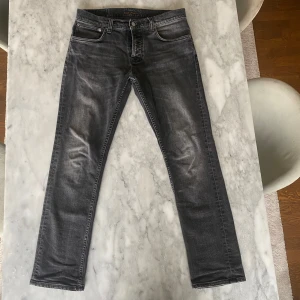 Grå jeans från Nudie Jeans grim Tim  - Nudie jeans modellen grim Tim, W32 L30. Jeansen är i bra skick. 