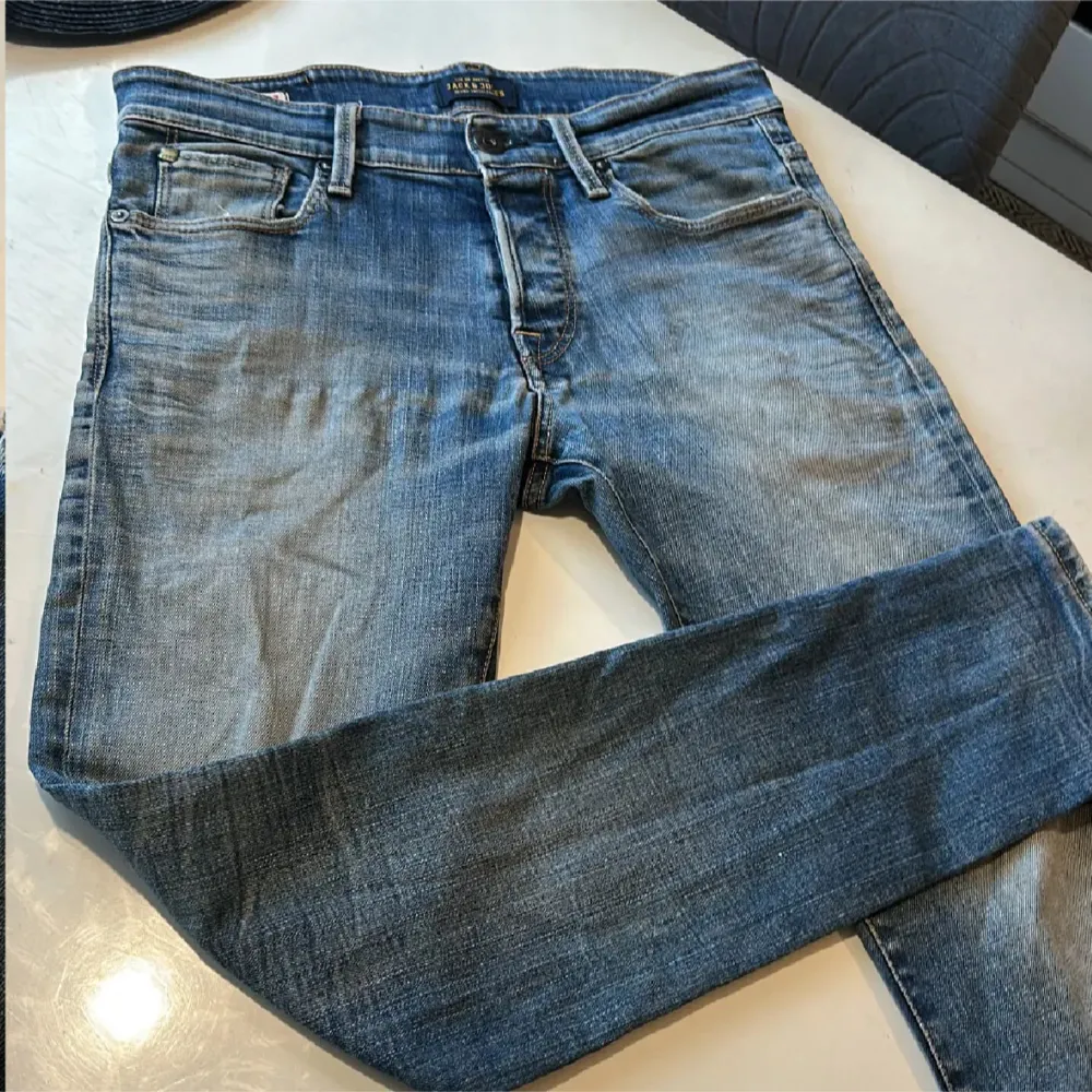 Snygga blå jeans från Jack & Jones med en klassisk femficksdesign. De har en normal passform och är tillverkade i slitstarkt denim. Perfekta för en avslappnad stil.. Farkut & Housut.