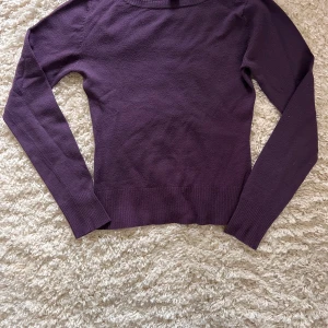 Lila tröja från H&M - Säljer en stilren lila tröja från H&M i storlek S. Tröjan har långa ärmar och en rund halsringning. Perfekt för kyligare dagar och lätt att matcha med olika outfits. Lite elastisk för finare passform. Lite smånopprig men annars hel  💜
