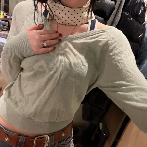 Ljusgrön v-ringad tröja - Säljer en ljusgrön v-ringad tröja med långa ärmar. Tröjan har en croppad passform och ribbade muddar vid ärmslut och nederkant. Använd max 2 gånger!! Passar xs-s