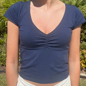 Mörkblå croppad topp - Supersöt mörkblå topp med v-ringning från Brandy Melville. Använd men är fortfarande i bra skick!!😻😻😻😇😇