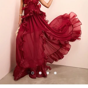 Söker❗️strl. S Vinröd långklänning med volanger - Elegant vinröd långklänning med volanger och öppen rygg. Klänningen har en flytande design med volangdetaljer som ger en dramatisk effekt. Perfekt för speciella tillfällen.