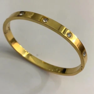 Guldarmband med stenar - Elegant guldarmband med infällda stenar runtom. Helt oanvänd, köpt utomlands. Materialet är rostfritt stål med 18K guldplätering. 